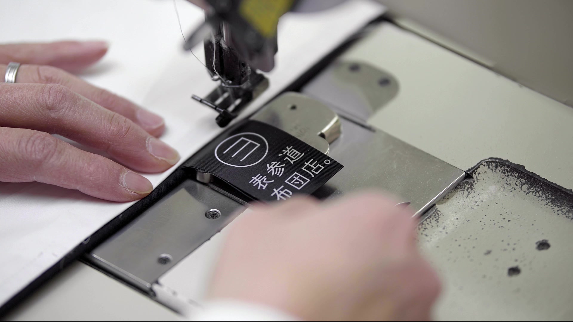 富士吉田の職人がブランドタグを縫い付ける